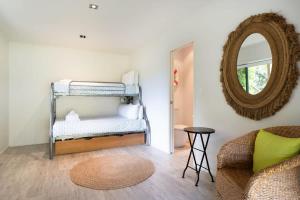 Habitación con litera y espejo. en Miro Magic - Stay Waiheke, en Palm Beach 7 fotos más