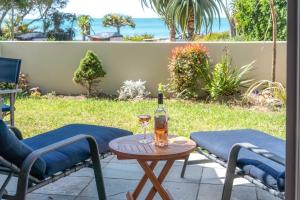 uma mesa com uma garrafa de vinho e duas cadeiras em The Sands Apartment 23 - Stay Waiheke em Onetangi