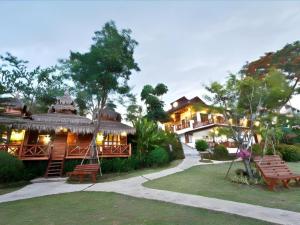 a resort with a large building with benches in the yard at Gin's Greenery Resort in Ban Hua Wiang
