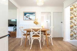 a kitchen and dining room with a table and chairs at Bach 14 - Stay Waiheke in Blackpool