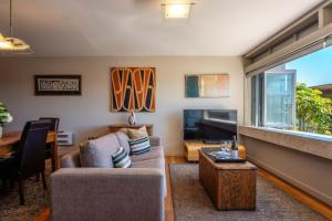 a living room with a couch and a table at The Sands - Apartment 12 - Stay Waiheke in Onetangi