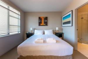 En eller flere senge i et værelse på The Sands - Apartment 12 - Stay Waiheke