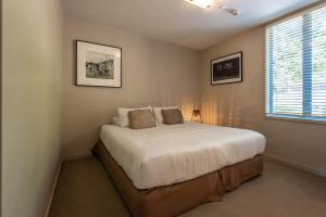 En eller flere senge i et værelse på The Sands - Apartment 12 - Stay Waiheke