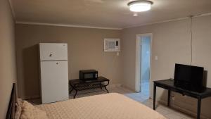 una habitación con una cama, una nevera y un televisor en Skyline Motel, en Las Vegas