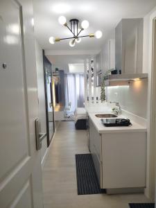 een witte keuken met een spoelbak en een fornuis bij Z Crib - Azure North in San Fernando