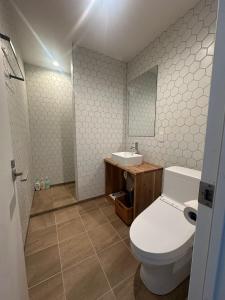 een badkamer met een wit toilet en een wastafel bij Pine House in Rankoshi