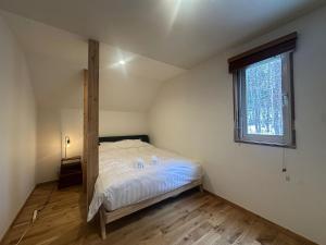 een slaapkamer met een bed in een kamer met een raam bij Pine House in Rankoshi