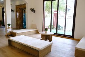 ein Wohnzimmer mit Bänken und einem Tisch in der Unterkunft Anna Home Ninh Binh in Kỳ Vĩ