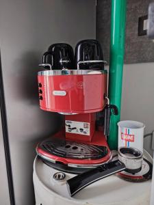 a red coffee maker sitting on top of a toilet at MR SQUARE apartment in Catania