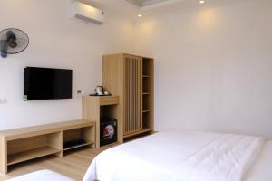 ein Schlafzimmer mit Bett und Flachbildfernseher in der Unterkunft Anna Home Ninh Binh in Kỳ Vĩ