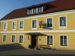 ein gelbes Gebäude mit einer Bank davor in der Unterkunft Gasthof Christine Enne in Albrechtsberg an der Grossen Krems