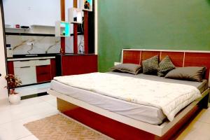 a bed in a bedroom with a green wall at Meg's Homestay in Jairāmpura