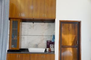 a bathroom with a sink and a wooden cabinet at Meg's Homestay in Jairāmpura +17 photos