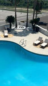 a swimming pool with two lounge chairs and twovisorvisor at The Landmark Hotel in Laredo +16 photos