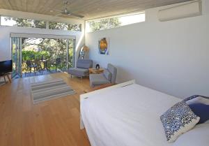 a bedroom with a bed and a living room at Tutiri in Oneroa - Stay Waiheke in Oneroa