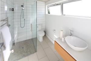 a bathroom with a sink and a shower and a toilet at Tutiri in Oneroa - Stay Waiheke in Oneroa