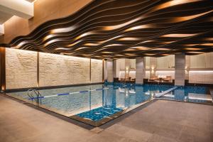 una piscina en un hotel con techo alto en The Grand Platinum Jakarta, en Yakarta