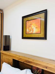 Cozy Private Studio with Garden Al Manhal, Abu Dhabi-5 في أبوظبي: لوحة معلقة على الحائط فوق رف خشبي