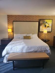 a bedroom with a large white bed with two lamps at The Landmark Hotel in Laredo