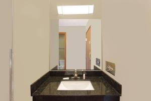 a bathroom with a sink and a mirror at Super 8 by Wyndham Normal Bloomington in Bloomington +28 photos