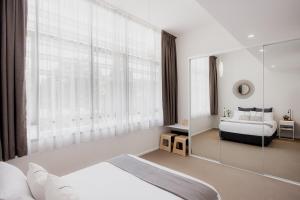 a bedroom with a bed and a large window at Heart of Hobart | CBD Apartment & Parking in Hobart +36 photos