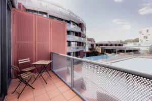 a balcony with two chairs and a table on a building at Heart of Hobart | CBD Apartment & Parking in Hobart