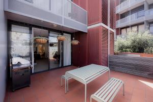 a patio with a bench and a table and a sink at Heart of Hobart | CBD Apartment & Parking in Hobart