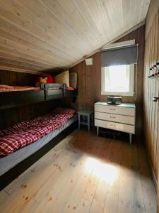 a bedroom with two bunk beds and a window at Mountain Cabin With Views Of Bonsenås in Tuddal