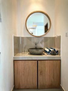 een badkamer met een wastafel en een spiegel bij Kemala Hospitality in Tegalalang +14 foto's
