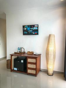 een woonkamer met een tv aan de muur en een tafel bij Kemala Hospitality in Tegalalang