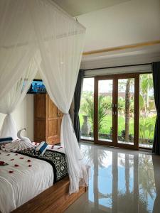 een slaapkamer met een bed en een groot raam bij Kemala Hospitality in Tegalalang
