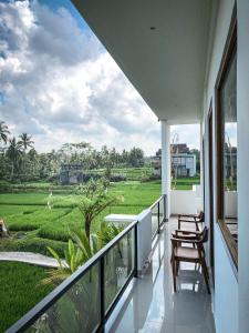 een balkon met uitzicht op een rijstveld bij Kemala Hospitality in Tegalalang