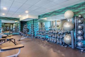 a gym with lots of tread machines in a room at Days Inn & Suites by Wyndham West Edmonton in Edmonton