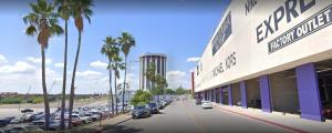 a parking lot with cars parked in front of a hotel at The Landmark Hotel in Laredo