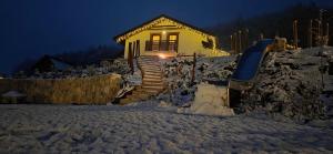 a house with stairs in the snow at night at Chata SNOW in Valča