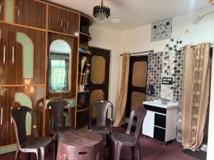 a room with chairs and a table and a mirror at Pine Guest House sawan tangmarg in Tangmarg