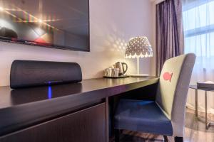 een bureau met een laptop en een stoel in de kamer bij Orange Hotel Hangzhou Wenyi West Road in Hangzhou +13 foto's