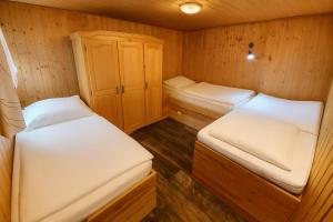 a small room with two beds and a cabinet at Camping Standard Bungalow Ferienwohnung auf Rügen - bis 5 Personen - nur 100m zum Naturstrand - mitten im Wald - Familien und Hunde herzlich willkommen - Feriensiedlung Schwalbennest in Dranske