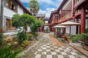 un patio de una casa con suelo a cuadros en Lijiang Wangfu Hotel, en Lijiang