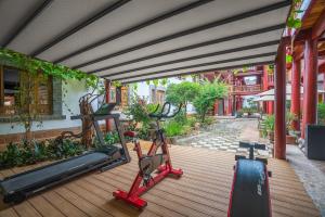 Un gimnasio con equipos de ejercicio en una terraza de madera. en Lijiang Wangfu Hotel, en Lijiang