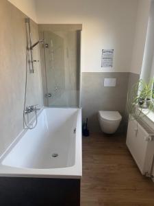 un bagno con una vasca bianca e un water di Ferienwohnung "Frieda" a Helsinghausen Altre 47 foto