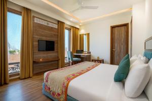 a hotel room with a bed and a television at Hotel SG Continental Amritsar !! Prime Location ! Parking ! Open Terrace in Amritsar