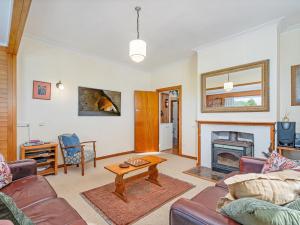 a living room with a couch and a fireplace at Coro Harbour View - Coromandel Holiday Home in Coromandel Town