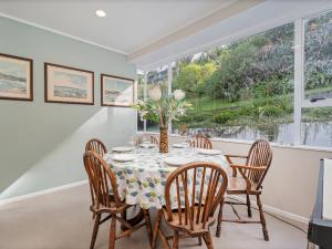 a dining room with a table and chairs and a window at Coro Harbour View - Coromandel Holiday Home in Coromandel Town +15 photos