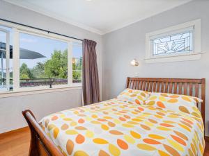 a bedroom with a bed and a window at Coro Harbour View - Coromandel Holiday Home in Coromandel Town