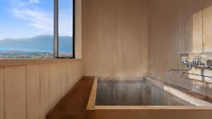 かっぱの宿旅館三治郎 في Zao: حمام مع حوض استحمام مع اطلالة