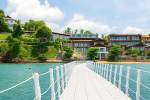 Un puente sobre el agua frente a unas casas. en The Summerland Panwa Beachfront 6BR Breakfast included, en Ban Ao Makham