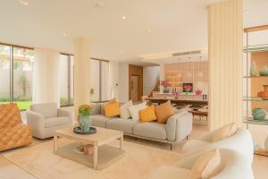 Una sala de estar con un sofá y sillas y una mesa. en The Summerland Panwa Beachfront 6BR Breakfast included, en Ban Ao Makham