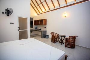 a bedroom with a bed and a table and chairs at Ceylon Princes Villa in Ahangama