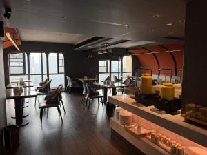 een eetkamer met tafels en stoelen en ramen bij Neyar星辰隐奢露台花园酒店--德思勤广场店 in Changsha